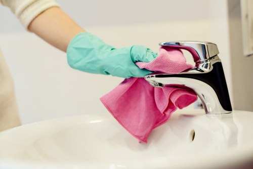 Cleaner detailing kitchen appliances during a Mayfair move-out clean